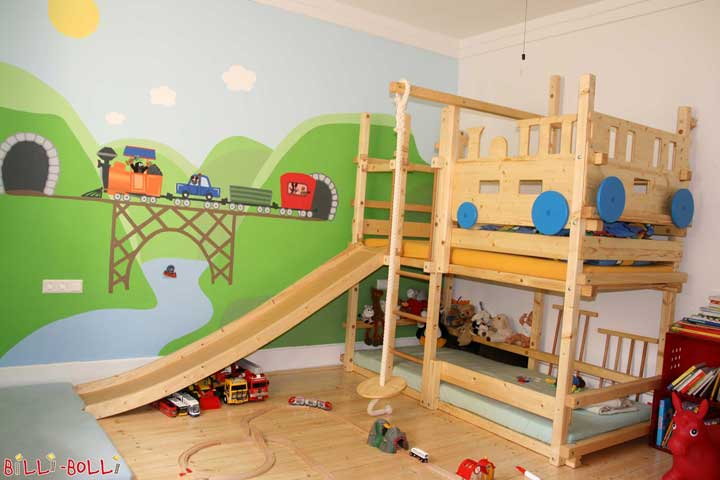 Billi-Bolli products and the parents’ creativity complementing each other: The bunk bed with train boards combined with the wall painting will make every trainman’s heart beat faster. And if the time schedule allows, the little engine driver can get rid of excess energy with swinging, climbing the rope or sliding from the top sleeping level.