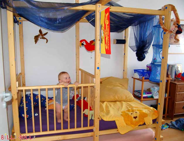 This Loft Bed Adjustable by Age is mounted at assembly height 2 as a cot. If only half of the sleeping area needs to be enclosed with gates, you will also have space right next to it for changing the diaper and sitting. You only need to order the baby gates in addition to mount the assembly option pictured.